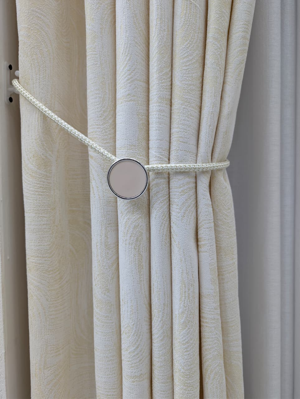 Magnetic round tieback on cream curtain